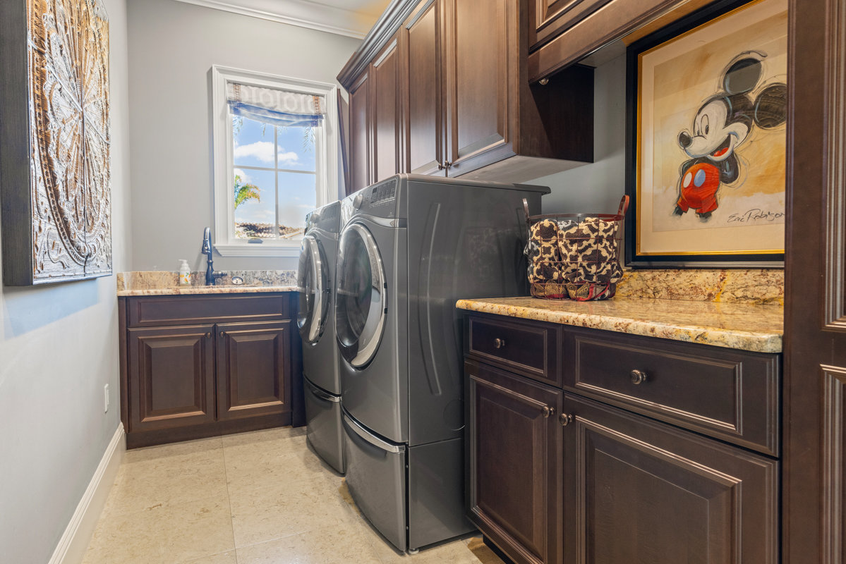 laundry room with dark wooden cabinets and mickey painting